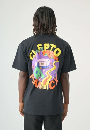 Black t-shirt featuring a colorful graphic design on the back with a mountainous landscape, house, and stylized text in bold colors.