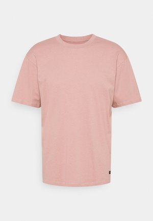 Simple light pink short-sleeve crewneck t-shirt with a small black label near the bottom hem on a plain white background.