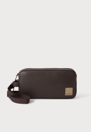 Sac bracelet rectangulaire en cuir marron foncé avec surface texturée, fermeture éclair supérieure, sangle réglable et petite étiquette de marque beige sur le devant.