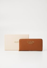 Portafoglio in pelle marrone con superficie testurizzata, brand dorato "LIU JO MILANO" sul davanti, accompagnato da una scatola regalo beige.