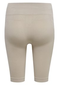 Leggings beige con vita alta, design a lunghezza ginocchio e texture a coste. Presentano un dettaglio triangolare sul retro.
