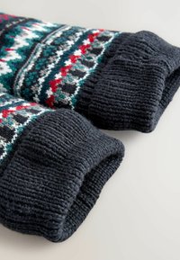 Polsini di maglione lavorati a maglia in un blu navy scuro con costine testurizzate. La sezione a motivo multicolore presenta disegni geometrici in rosso, verde, bianco e grigio.