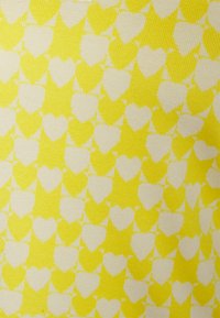Tecido de malha com um padrão repetido de pequenos corações brancos sobre um fundo amarelo vibrante, com uma textura suave.