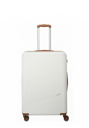 White hard-shell suitcase with vertical ribbed texture, brown accents, extendable handle, and four wheels for mobility.