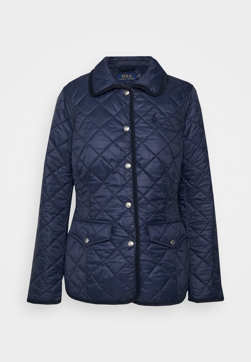 Granatowa pikowana kurtka w diamentowy wzór, z srebrnymi zatrzaskami, dwoma przednimi kieszeniami i okrągłym kołnierzem. Posiada kontrastowe przeszycia.