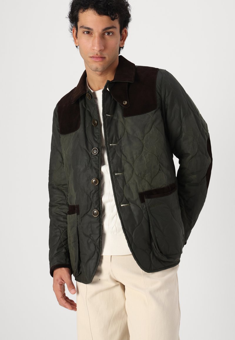 Quilted Jacke in Dunkelgrün mit braunen Wildlederakzenten, ausgestattet mit Knopfverschlüssen, zwei Vorderaschen und einem Kragen.