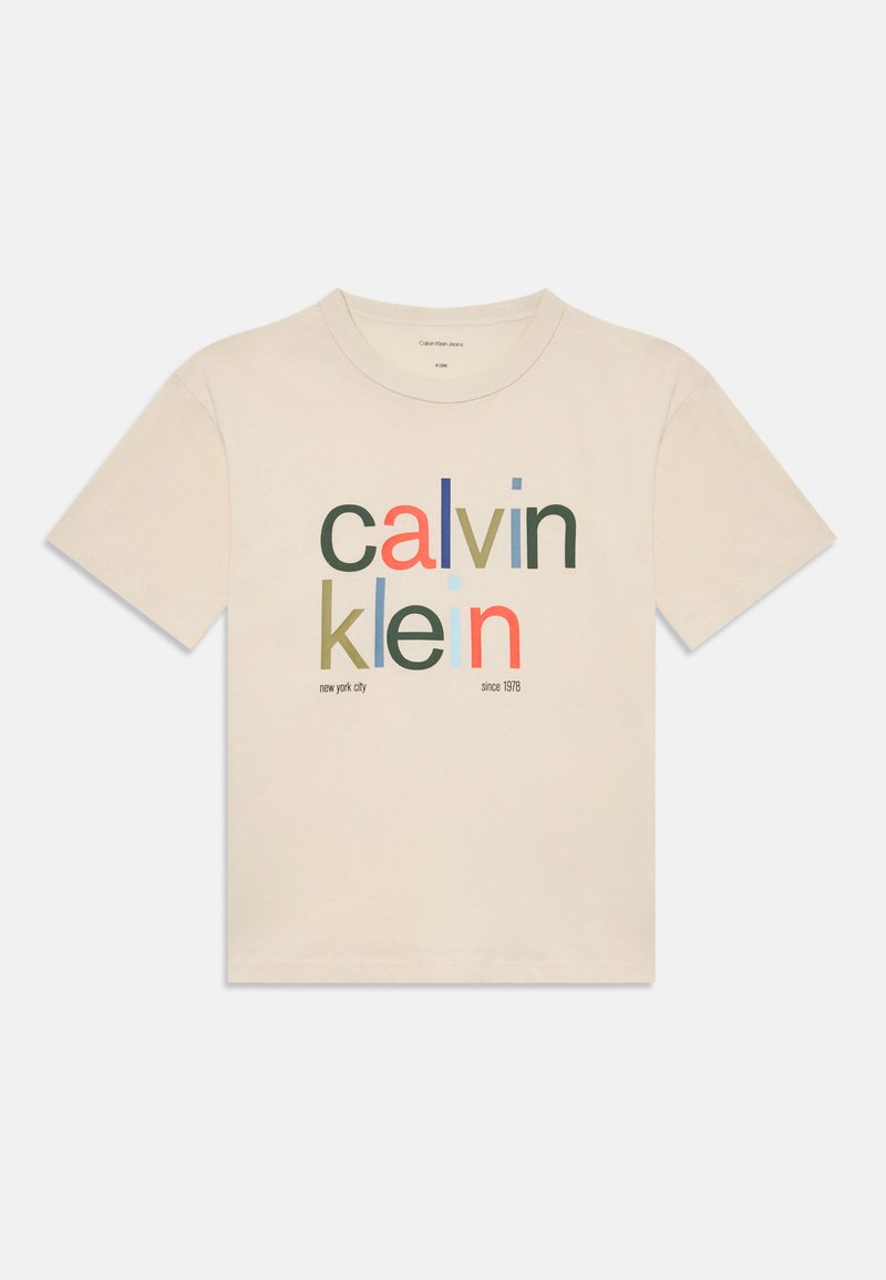 Bežs īsās piedurknes T-krekls ar daudzkrāsainu "calvin klein" tekstu un mazu drukātu "new york city" un "since 1978" uz priekšpuses.