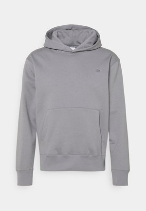 Sweat à capuche gris clair avec poche kangourou devant et petit logo discret sur la poitrine gauche, présenté sur fond blanc.