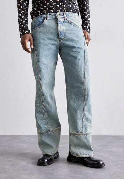 Jeans din denim de culoare albastru deschis, cu un design cu picioare largi, prezentând modele pe laterale, cusături contrastante și un stil clasic cu cinci buzunare.