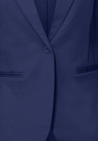 Blazer bleu foncé avec revers crantés, fermeture à un bouton et deux poches passepoilées horizontales à l'avant.