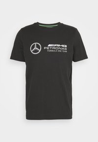 Czarny bawełniany t-shirt z okrągłym dekoltem, z białymi nadrukowanymi logo: Mercedes-Benz, AMG oraz PETRONAS, a także napisem "Zespół Formuły 1".