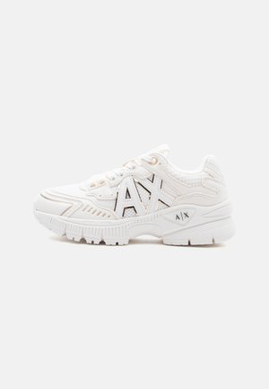 White chunky sneaker with mesh panels, beige accents, and large "AX" logo on side and sole, on a plain light background.