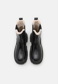 Μαύρες ankle μπότες με απαλό δερμάτινο εξωτερικό, επένδυση από ψεύτικη γούνα, στρογγυλή μύτη και υφασμάτινη σόλα με υφή; στα πίσω μέρη διαθέτουν ταμπά. 