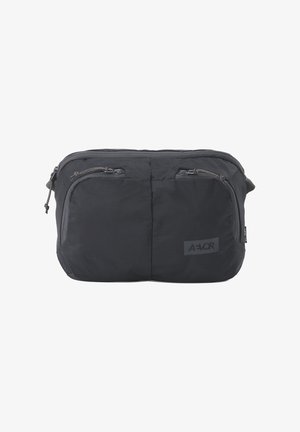 Schwarze Bauchtasche aus Stoff mit zwei vorderen Reißverschlusstaschen und einem Hauptfach, mit einem kleinen Markenlogo unten rechts.
