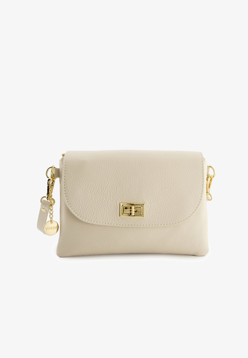 Beige leren crossbody tas met een klepsluiting en gouden hardware. Voorzien van een ronde charm tag met de tekst "Venezia." Gestructureerd oppervlak.