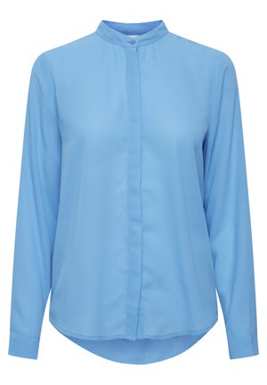 Svetlo modra srajca z dolgimi rokavi in ovratnikom v obliki trakca. Mehka tkanina se nežno ovije z zaobljenim robom in sprednjim gumbom.