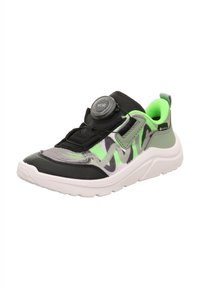 Schwarzer und grüner Sportschuh mit strukturiertem Obermaterial, Mesh-Einsätzen, einer runden Drehverschluss und einer dicken weißen Sohle. Mit abstrakten Musterdetails.