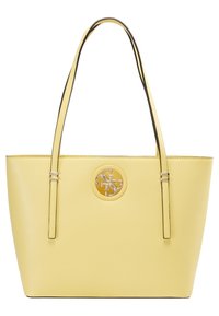 Żółta skórzana torba na ramię z dwoma smukłymi uchwytami, okrągłym złotym akcentem logo na środku oraz gładkimi, teksturowanymi bokami.