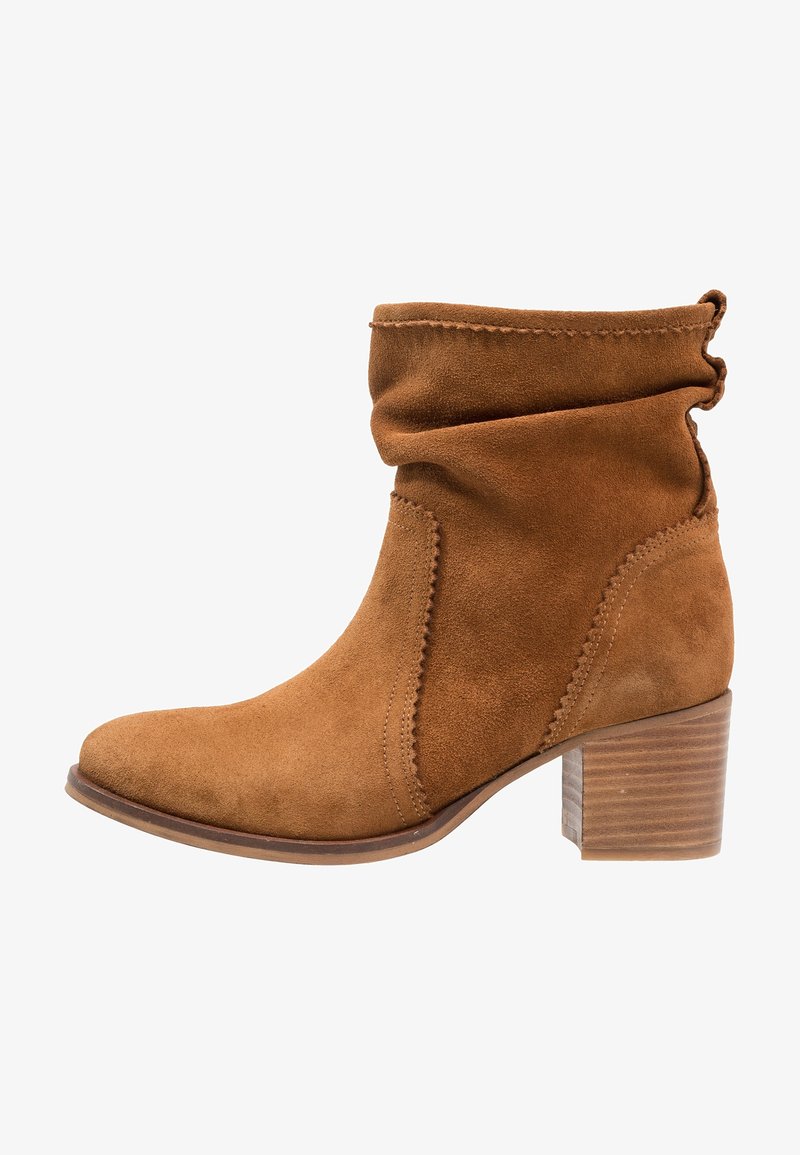 Bruna mockaskinnsankelkängor med en slouchy design, rund tå och en staplad träklack. Har dekorativ sömnad längs sömmen.