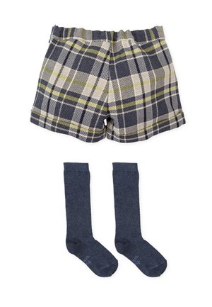 Pantalones cortos de cuadros en azul marino, crema y verde lima con una cinturilla elástica, combinados con calcetas oscuros hasta la rodilla. Ambos artículos hechos de tela suave.