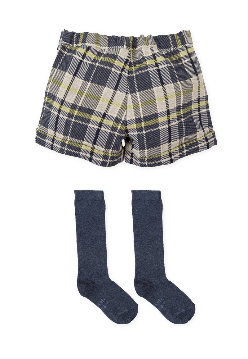Pantalones cortos de cuadros en azul marino, crema y verde lima con una cinturilla elástica, combinados con calcetas oscuros hasta la rodilla. Ambos artículos hechos de tela suave.