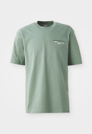 Zelena bombažna majica s kratkimi rokavi, okroglo izrezano ter izvezenim logotipom "Dickies Workwear Since 22", ki vsebuje grafike gora in rib.