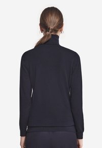 Granatowy sweter z golfem wykonany z miękkiego materiału, z długimi rękawami, ściągaczami przy mankietach i dopasowanym krojem, widocznymi szwami na ramionach.