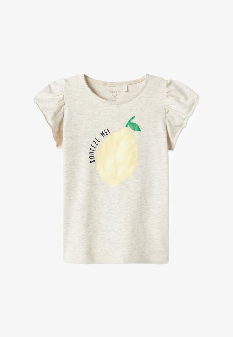 Světle béžové bavlněné tričko s balónkovými rukávy, s grafikou žlutého citronu a textem "Squeeze Me!" v černé barvě kolem designu.