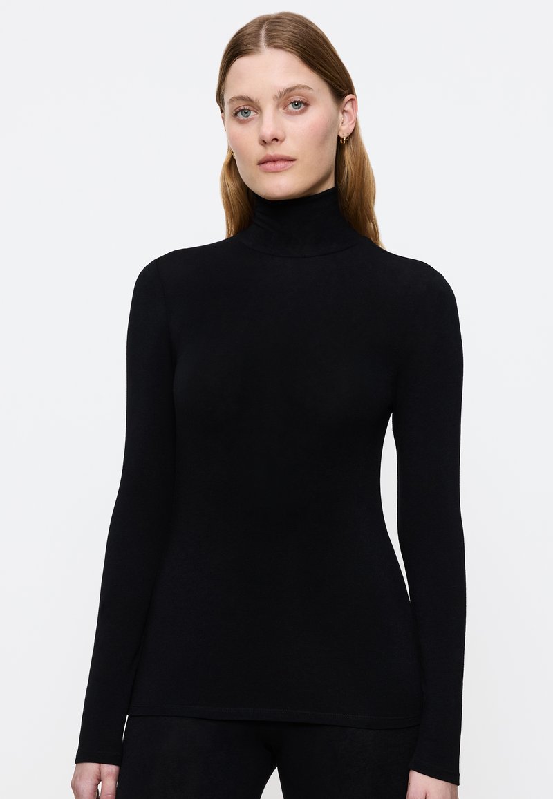 Maglietta nera a maniche lunghe con colletto alto realizzata in materiale morbido, caratterizzata da un design aderente e una texture liscia, con un collo alto per una copertura aggiuntiva.