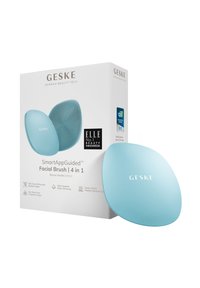 Spazzola per il viso Geske SmartAppGuided™, silicone blu chiaro, forma ergonomica, superficie testurizzata, confezione in scatola con logo e dettagli del prodotto.