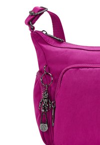 Borsa a tracolla fucsia con finitura in tessuto, con una cerniera prominente, dettaglio portachiavi e una tracolla testurizzata.