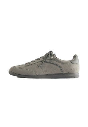 Baskets basses en daim gris avec fermeture à lacets et une semelle fine en caoutchouc foncé, vues de côté sur fond blanc.