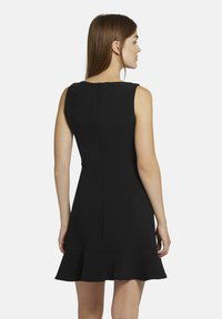 Schwarzes ärmelloses Kleid mit einem taillierten Oberteil, ausgestelltem Rock und Reißverschluss im Rücken. Glattes Material mit einem klaren, minimalistischen Design.
