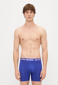 Μπλε μποξεράκια φτιαγμένα από ελαστικό ύφασμα με σφιχτή εφαρμογή, που διαθέτουν λευκή ετικέτα με το λογότυπο 'BJÖRN BORG'.