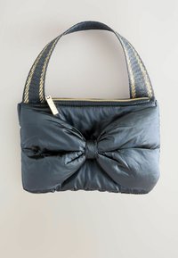 Svart vadderad handväska med en bågformad detalj på framsidan, utrustad med en guld zip och ett texturerat band med guldaccenter.