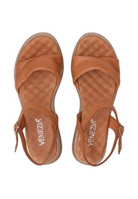 Tan leren sandalen met een kruisbandontwerp, geperforeerde zolen en een enkelband met metalen gesp. Soepele textuur en gevoerde zool.