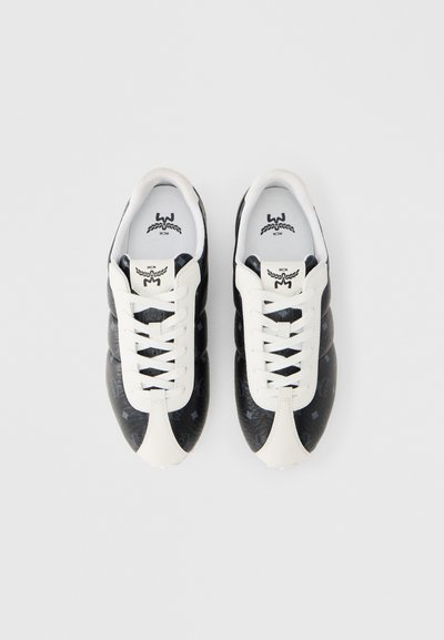 Ασπρόμαυρα αθλητικά παπούτσια με υφασμάτινο μαύρο πάνω μέρος, λευκή δερμάτινη μύτη και λευκά κορδόνια. Διαθέτουν λογότυπο στην γλώσσα και στα πλάγια.