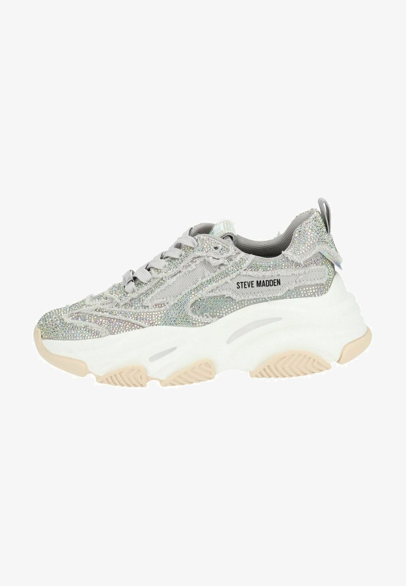 Silberner Sneaker mit einer strukturierten, glitzernden Oberseite, ausgestattet mit einer chunky weißen Sohle und grauen Akzenten. Schnürung vorne und Branding an der Seite.