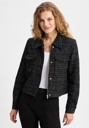 Black tweed jacket with a cropped design, two chest pockets, and a button-front closure. Features a collared neckline and textured fabric.