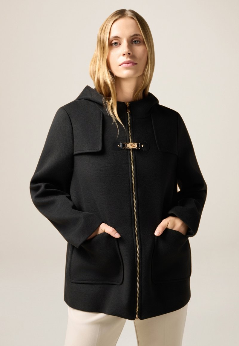 Czarny płaszcz z kapturem, zapinany na zamek, z dwoma bocznymi kieszeniami, złotymi detalami oraz teksturowanym materiałem. Czyste linie i minimalistyczny design.