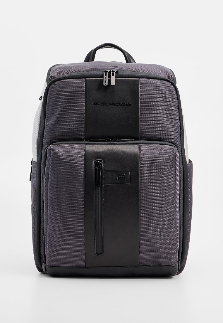 Zaino grigio e nero con un esterno testurizzato, multiple tasche con cerniera, materiali a contrasto e una maniglia imbottita.