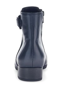Bottines en cuir noir avec un petit talon carré, dotées d'une fermeture éclair sur le côté et d'une sangle ajustable pour un maintien sécurisé. Texture lisse et brillante.