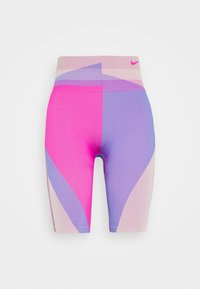 Nike pyöräilyhousut, jotka on valmistettu joustavasta kankaasta ja joissa on geometrisia paneeleja vaaleanpunaisessa, purppurassa ja beigeessä. Housuissa on istuva muotoilu ja korkea vyötärö.