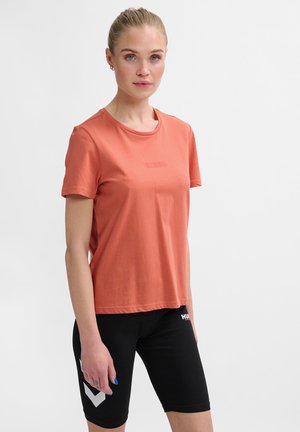 Korte mouwen, koraalkleurig T-shirt van zachte katoen met een klassieke ronde hals en subtiele tonale logo op de borst, gecombineerd met zwarte fietsbroek.