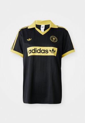 Svart sportstrøye med gule detaljer, med stripet design, v-hals og adidas-logoen tydelig vist på brystet.