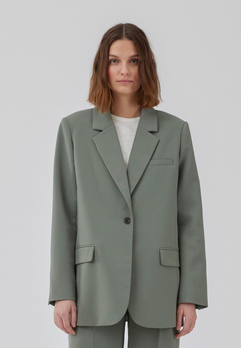 Lys grønn blazer med en strukturert design, klaffelapper, enkeltknapplukking, frontlommer og en glatt tekstur.