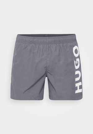 Graue Badehose aus leichtem Material mit elastischem Bund. Auffällige weiße "HUGO"-Markierung auf der linken Seite.