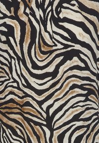 Zebra-gepatroneerde stof met zwarte, crèmekleurige en bruine golven. De textuur lijkt zacht met een pluche afwerking, wat de contrasterende kleuren benadrukt.
