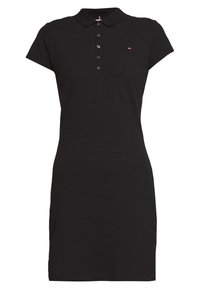 Černé polo šaty z bavlny s límečkem, krátkými rukávy, zapínáním na knoflíky a malým logem na levé straně hrudi.