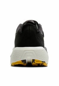 Zwarte sportschoen met een grijze mesh bovenkant, textuur op de hak en een witte zool met gele accenten en een gemustreerde tread.